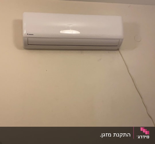 יחידת מיזוג אוויר מותקנת על קיר לבן